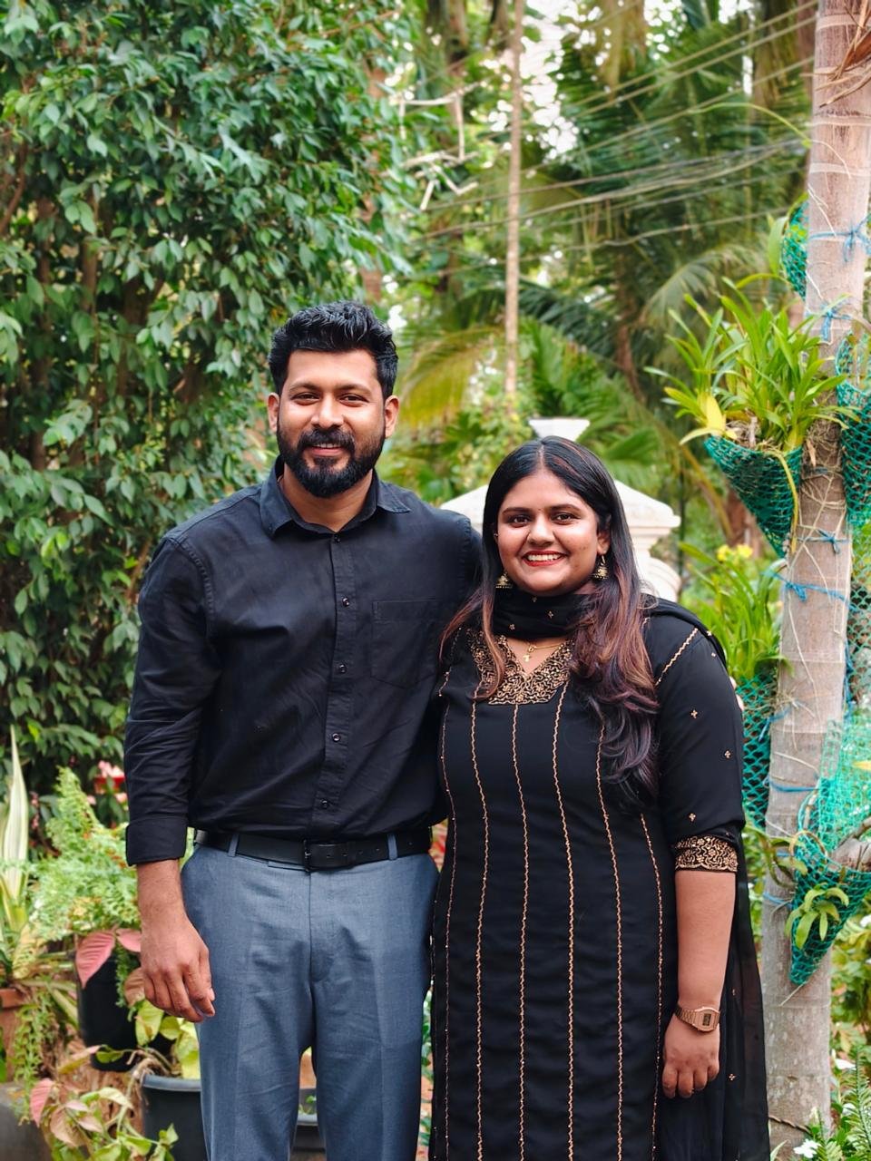 Bibin and Alicia standing together in a garden
